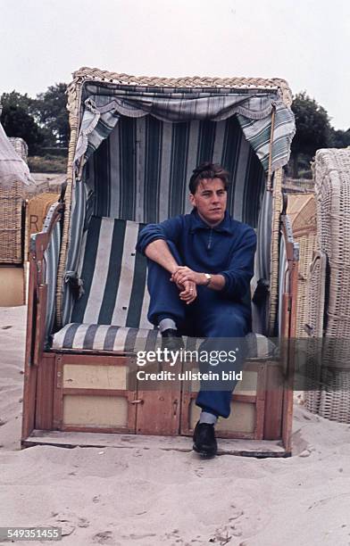 East Germany: Summer at the Baltic Sea, a man sits in a wicker beach chair, probably on Ruegen Island