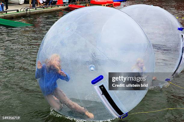 Kieler Woche 2011, sailing event, summer fair, childrens festival, children playing in large balloon on the water surface