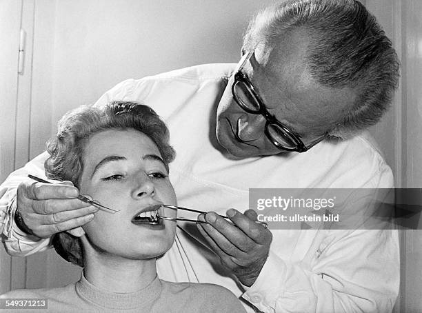 Germany, dentist inspecting teeth of a woman in the fifties