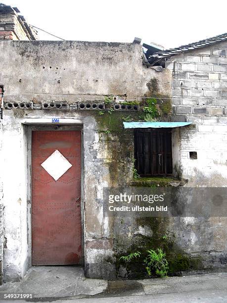 China, Ningbo: A door in the old town, May 2012 A moss-growned window next to a door.