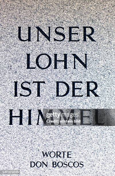 Unser Lohn ist der Himmel. Sprichwort von Don Bosco auf einem Grabstein auf einem Friedhof