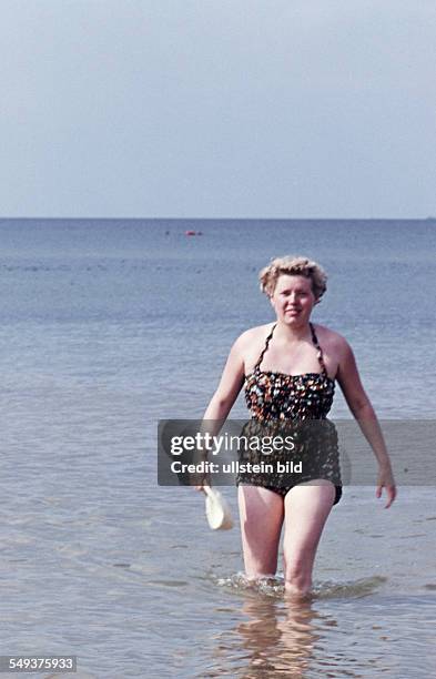 East Germany: Summer at the Baltic Sea, a woman walks in the water, probably on Ruegen Island