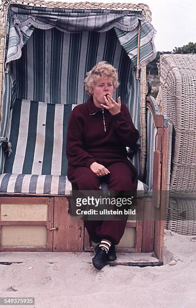 East Germany: Summer at the Baltic Sea, a young woman sits in a wicker beach chair, probably on Ruegen Island