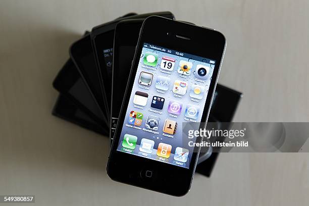 Smartphones / Handys verschiedener Herstelelr liegen auf einem Tisch , oben ein Apple iPhone 4