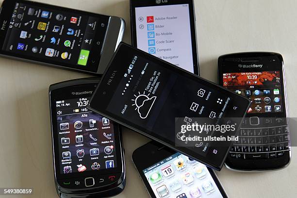 Smartphones / Handys verschiedener Herstelelr liegen auf einem Tisch