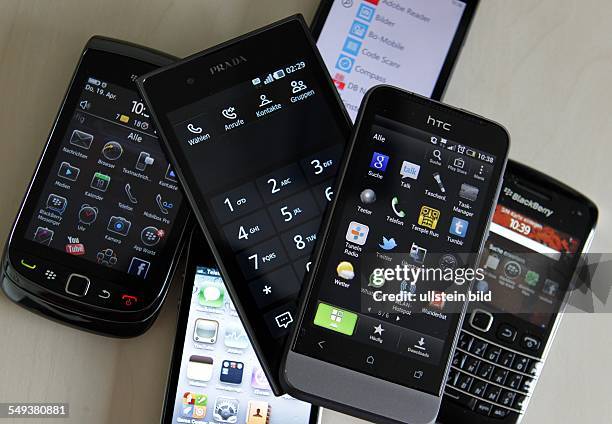 Smartphones / Handys verschiedener Herstelelr liegen auf einem Tisch