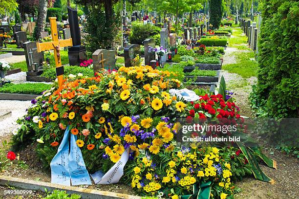 Auf einem Friedhof befindet sich ein frisches Grab nach einem Begräbnis.