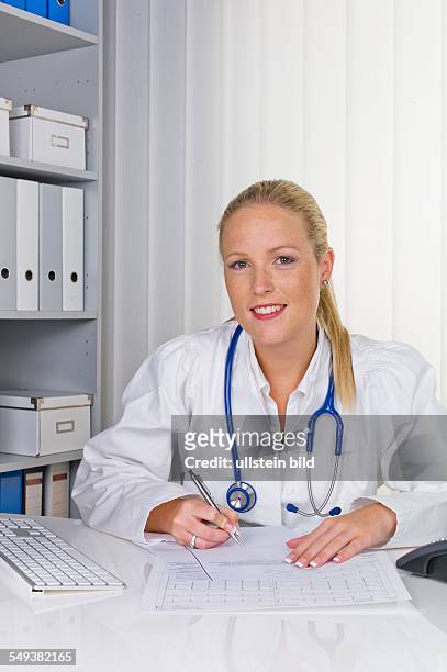Eine junge Ärztin mit Stethoskop in ihrer Arztpraxis.