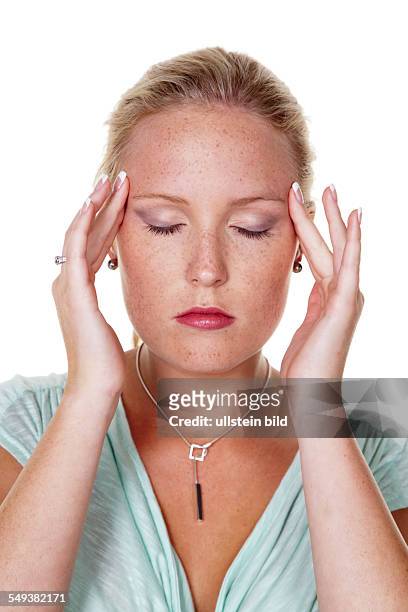 Eine junge Frau hat Kopfweh und Migräne. Akupressur als Therapie.