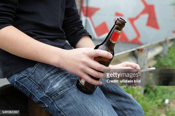 Feature Jugendliche und Drogen , Jugendlicher trinkt Bier und raucht eine Zigarette