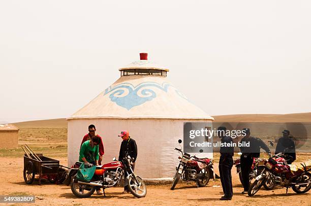 Mongolen vor einer Jurte im Grasland Xilamuren
