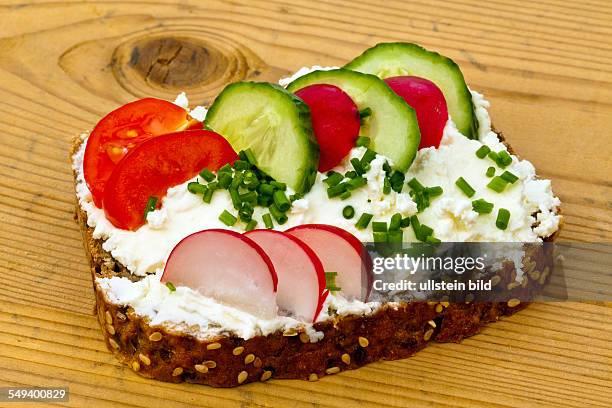 Ein Brot mit Quarkaufstrich und Gemüse zur gesunden Ernährung.