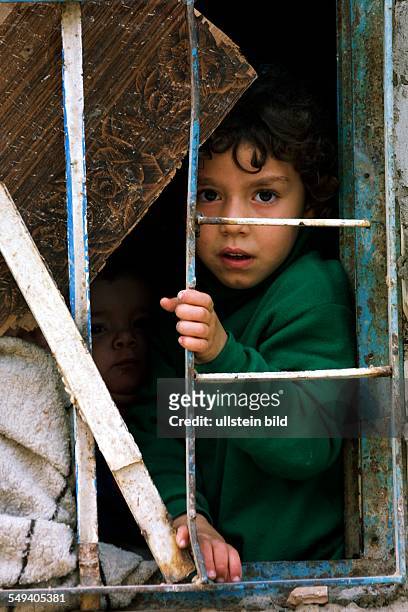 Iraq, Baghdad: The district Al-Bahadia in the east town. Children behind a barred window