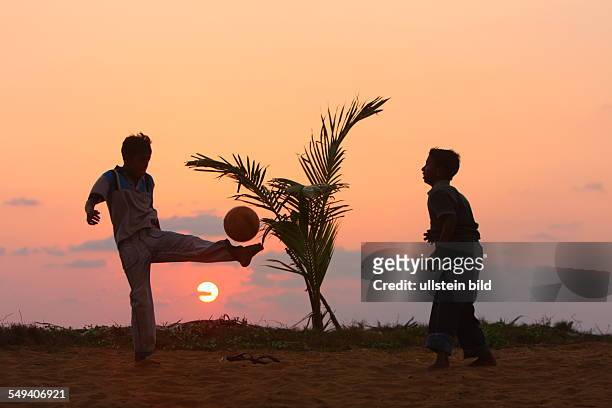 Sri Lanka, Uswetaketyawa: Children playing football at sunset