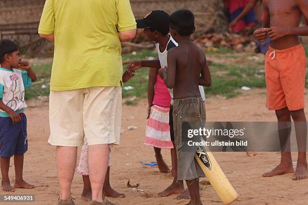 Sri Lanka, Negombo: The Salesian fight against pedophilia and helps the young boys to get education. A western tourist shares out sweets to the...