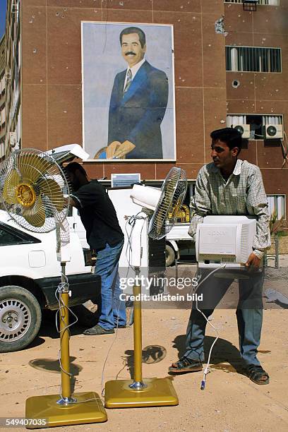 Iraq, Baghdad: Plunder of the planning department by the population. Men steal a computer and ventilators