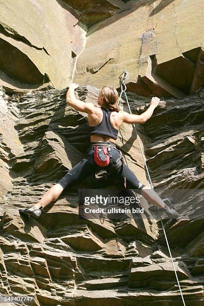 Germany, Hattingen: The climbing crag of the "Deutschen Alpenverein DAV Isenberg". A woman climbs at a rock face