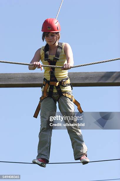 Germany, Xanten: The leisure centre Xanten F-Z-X. The High Rope Adenvture Park. A young woman climbs