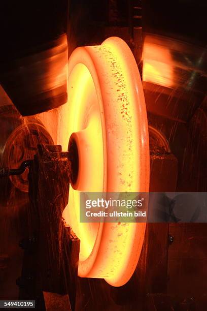 Germany, Bochum: Forming at the wheel rolling mill of the wheel tyre and wheelset manufacturer Bochumer Verein Verkehrstechnik. A glowing wheel