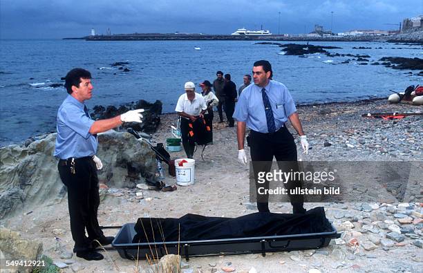 Spain. Africans try to immigrate over the straits of Gibraltar. Undertakers carry away the bodies.