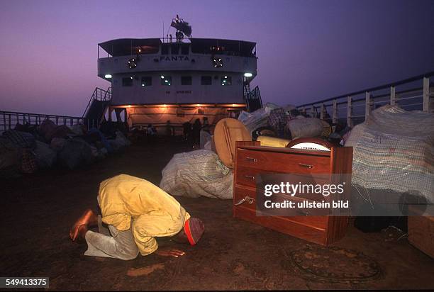 Sierra Leone, repatriated refugees from Sierra Leone reaching Freetown on board of the ferry Fanta. Praying refugee