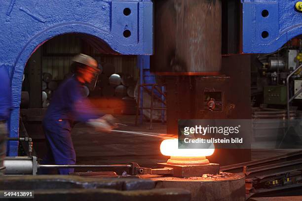 Germany, Bochum: Forging of the 5 tons hammer of the wheel tyre and wheel set manufacturer Bochumer Verein Verkehrstechnik. A worker at forging