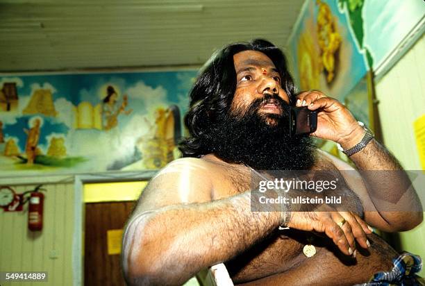 Germany, Hamm, 1999: Hindu-Tamils in Germany.- The temples cook talking on the telephone, Sri Kamadschi Ambal Temple.