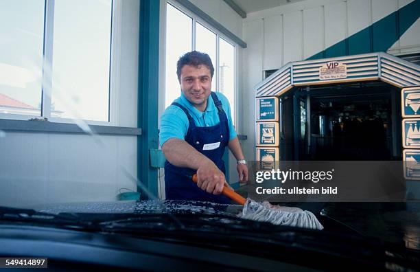 Germany, Luenen, 1999: Turkish businessmen in Germany.- The manager of a VIP-washing shop cleaning cars, 1 employee.