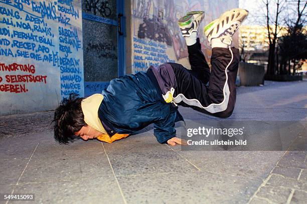 Germany, Berlin: Hip Hop in Berlin.- Young Turkish person doing breakdance on the street, Kreuzberg.