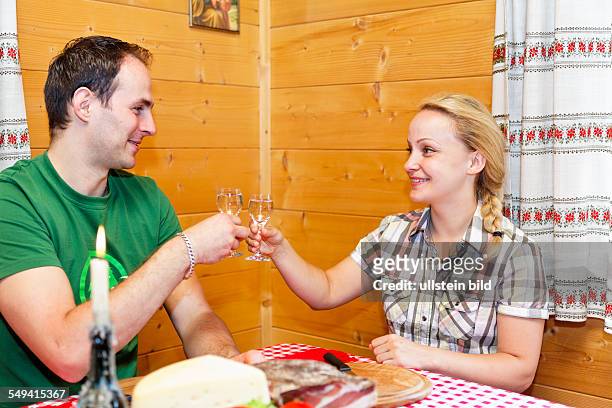 Junges Paar in Stube beim Weintrinken