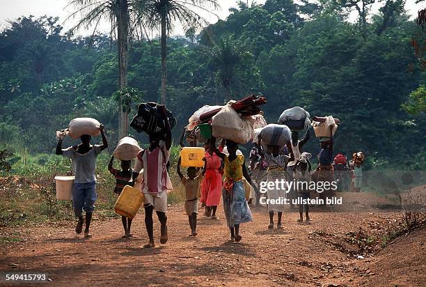 Guinea, refugees from Sierra Leone on their way from the refugee camp Mongo to Conakry. They bear her possessions on their head