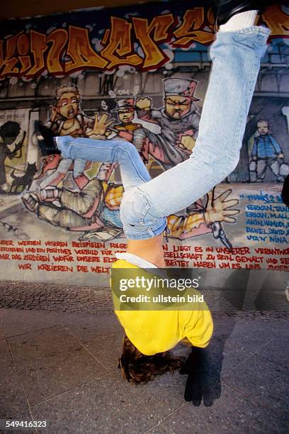 Germany, Berlin: Hip Hop in Berlin.- Young Turkish person doing breakdance on the street, Kreuzberg.