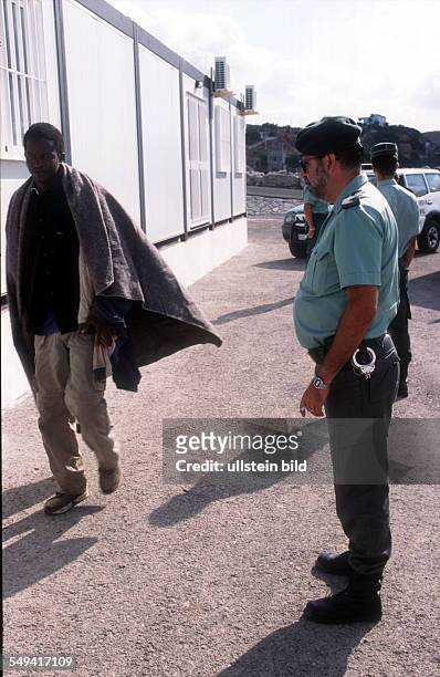 Spain, Tarifa: An immigrant is arrested by the Guardia Civil and is brought to the collective accommodation at the harbour in Tarifa