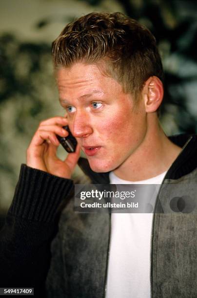Germany: Free time.- Portrait of a young man; he is calling with his mobile phone.