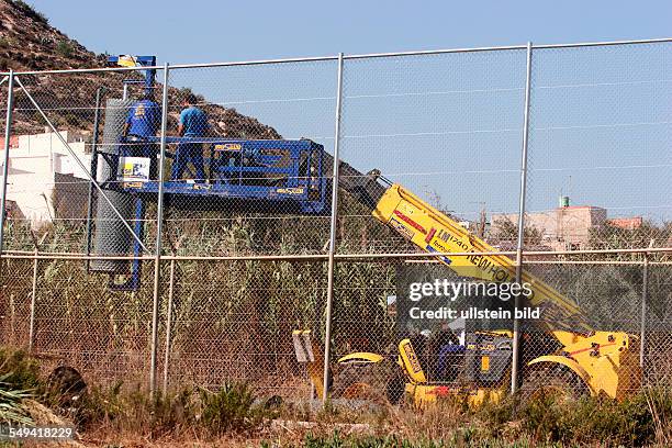 Spain, Melilla: Repairing of the border at the area of Rostrogordo after Africans tried to pass the border illegally. The fence is built up from 3 to...