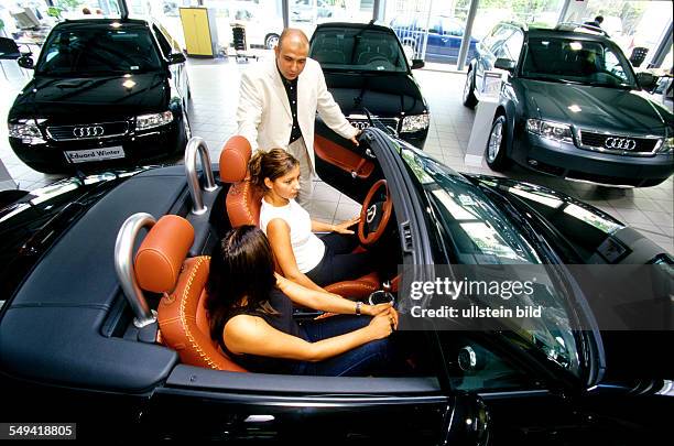 Deutschland, Berlin: VW/Audi.- Two turkish women and a friend in the car-centre, Audi TT.