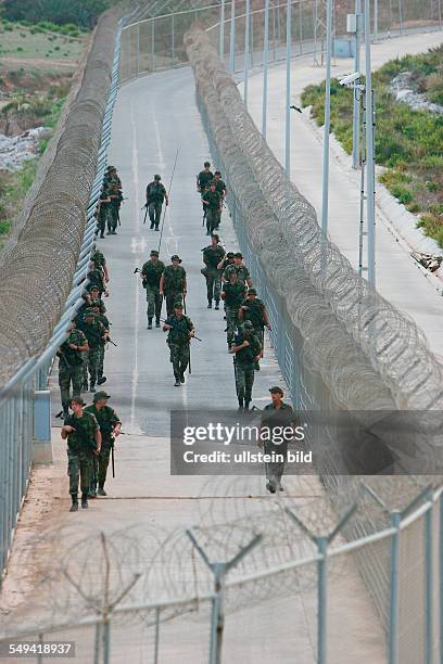 Spain, Ceuta: The border fence in the industrial estate. The spanish legion or rather the army at the border patrol.