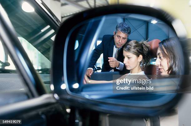 Deutschland, Berlin: VW/Audi.- Two turkish women at AUDI; Ali Haydar Berkpinar, a turkish salesman giving advices at the Audi TT.