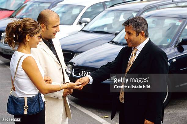 Deutschland, Berlin: A turkish couple at AUDI.- Ali Haydar Berkpinar, a turkish salesman handing over the key.