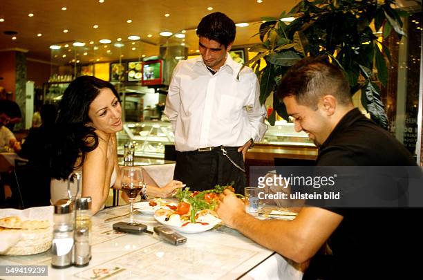 Deutschland, Berlin: A turkish couple eating dinner in the bar -restaurant Kaplan.
