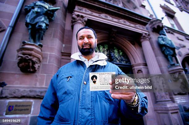 Germany, Frankfurt: Place of naturalization at the registry office.- A new citizen of Germany with his passport.