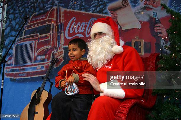 Germany, Bonn, Little boy sitting on Santa Claus legs
