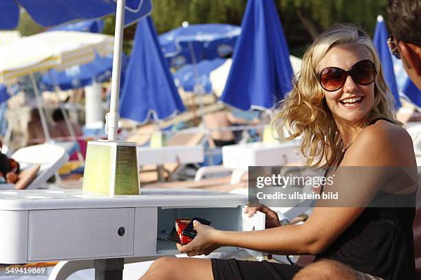 Turkey: Beach safe; a young woman locking objects of values.