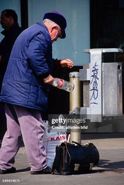 Germany, Dortmund: Poverty in Germany.- An old man collecting pledge-botltles out of a dust-bin.