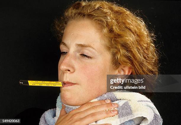 Deutschland: A young woman being sick; fever, sore throat and headache.