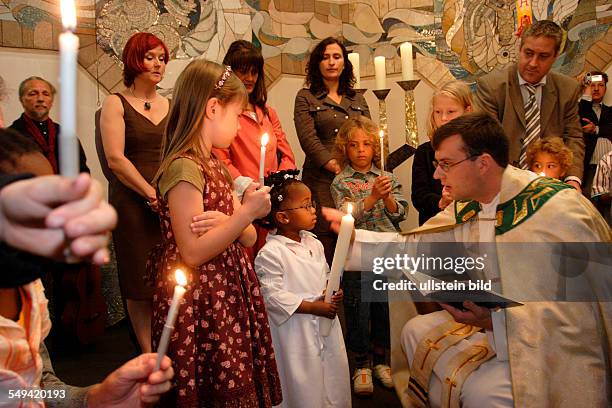 Germany, Oberhausen: Baptising ceremony of an adopted child coming from South Africa in the church St. Pankratius.