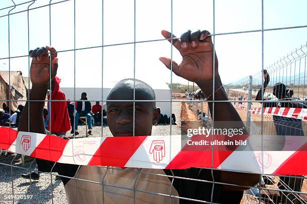 Melilla: Migrants behind a fence at the Centro de Estancia Temporal de Inmigrantes CETI in the spanish exclave. Because of the high number of border...