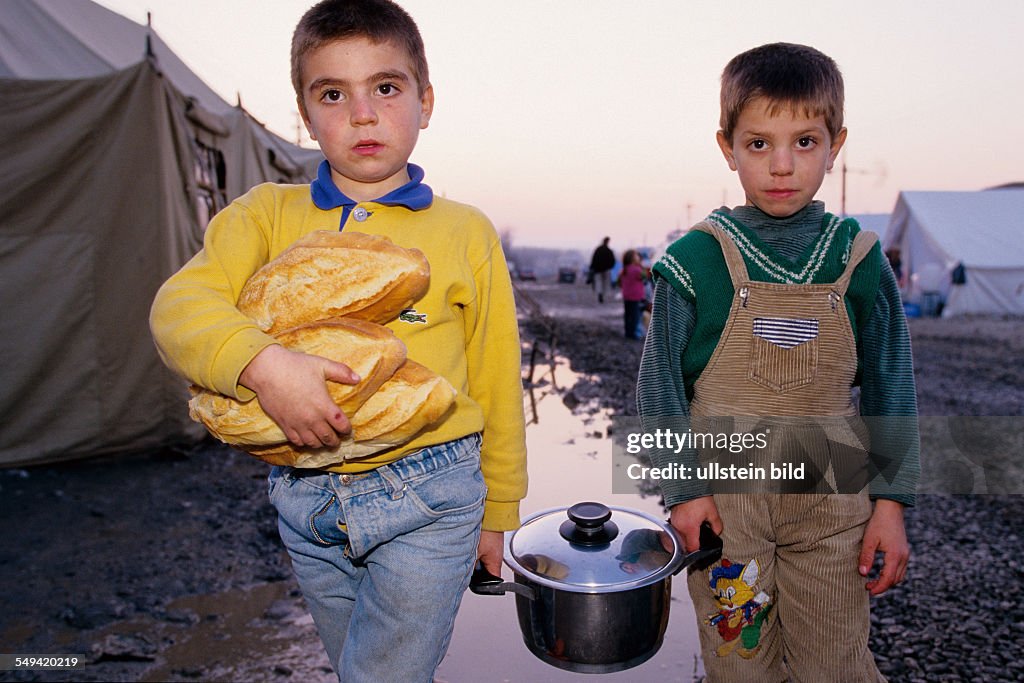 TUR, Turkey, Mittelmeer, Duezce: After the earthquake.- Children carrying the dinner which was distributed by the Red Half-Moonto the provisional accommodation/tent city; Lent (Ramazan).