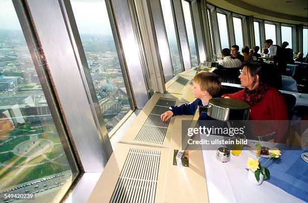 Germany, Berlin: Alexander square, tourists in a cafe at the television tower.