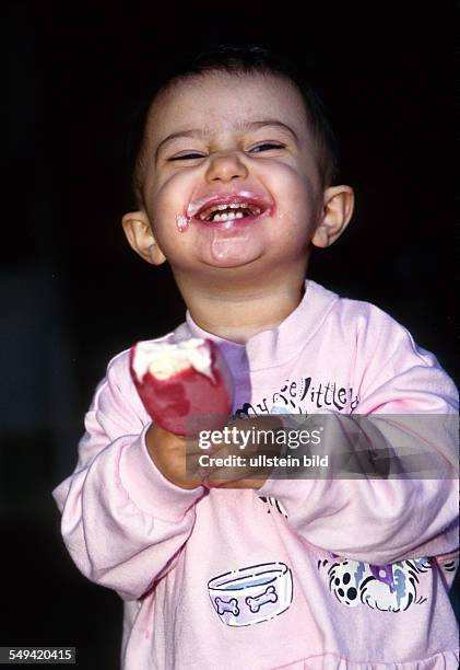 Germany: Infant, 1 1/2 years old, eating ice-cream.